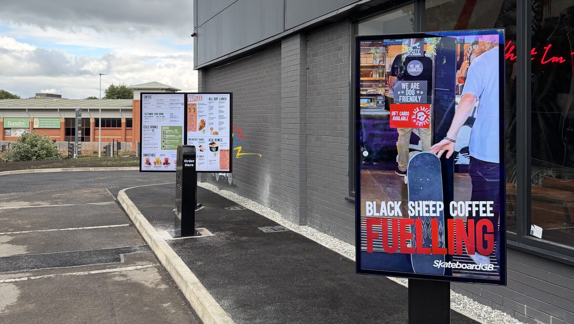 Drive-thru outdoor digital signage outside a Black Sheep Coffee